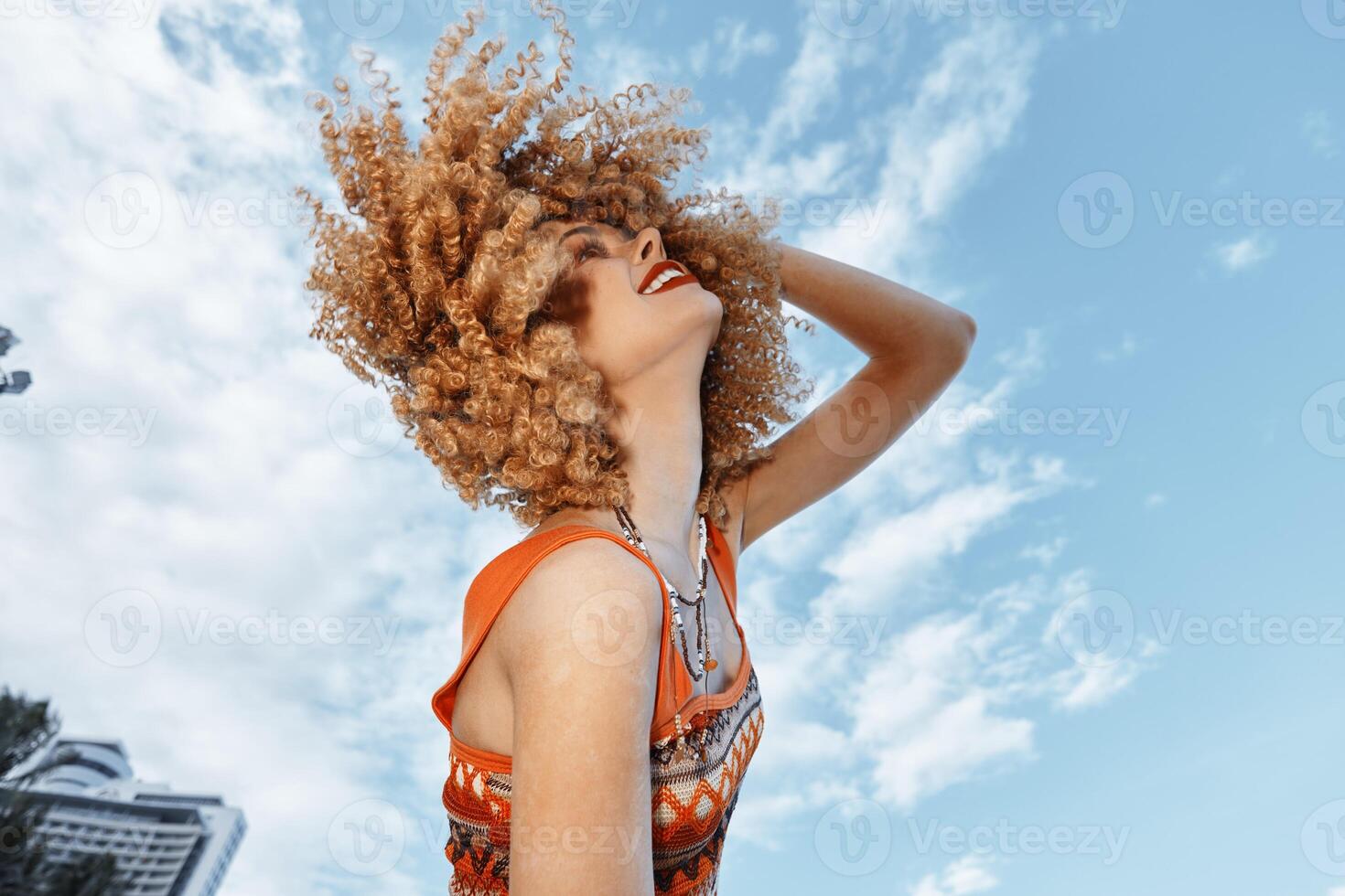 Beach Beauty. A Smiling Woman Dancing with Freedom and Joy in Curly Hair, Enjoying a Happy Vacation photo