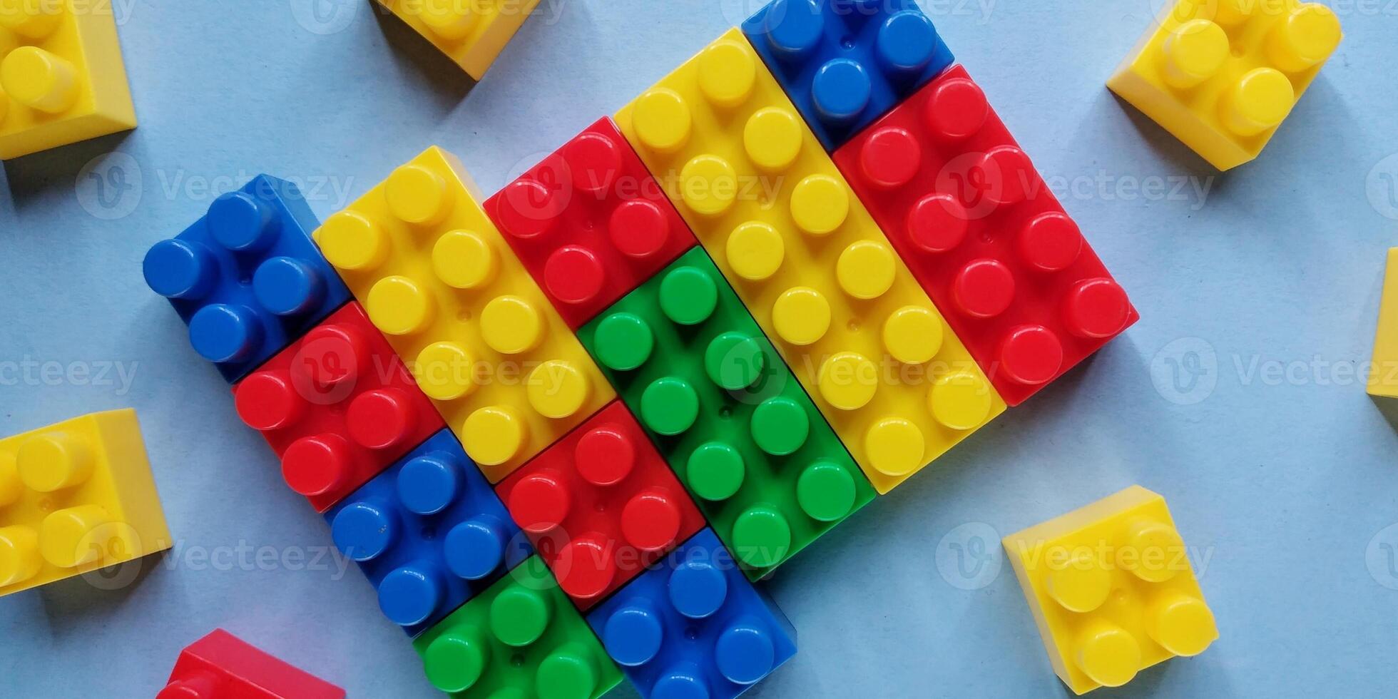 Plastic building blocks on a blue background. Minimal concept. photo