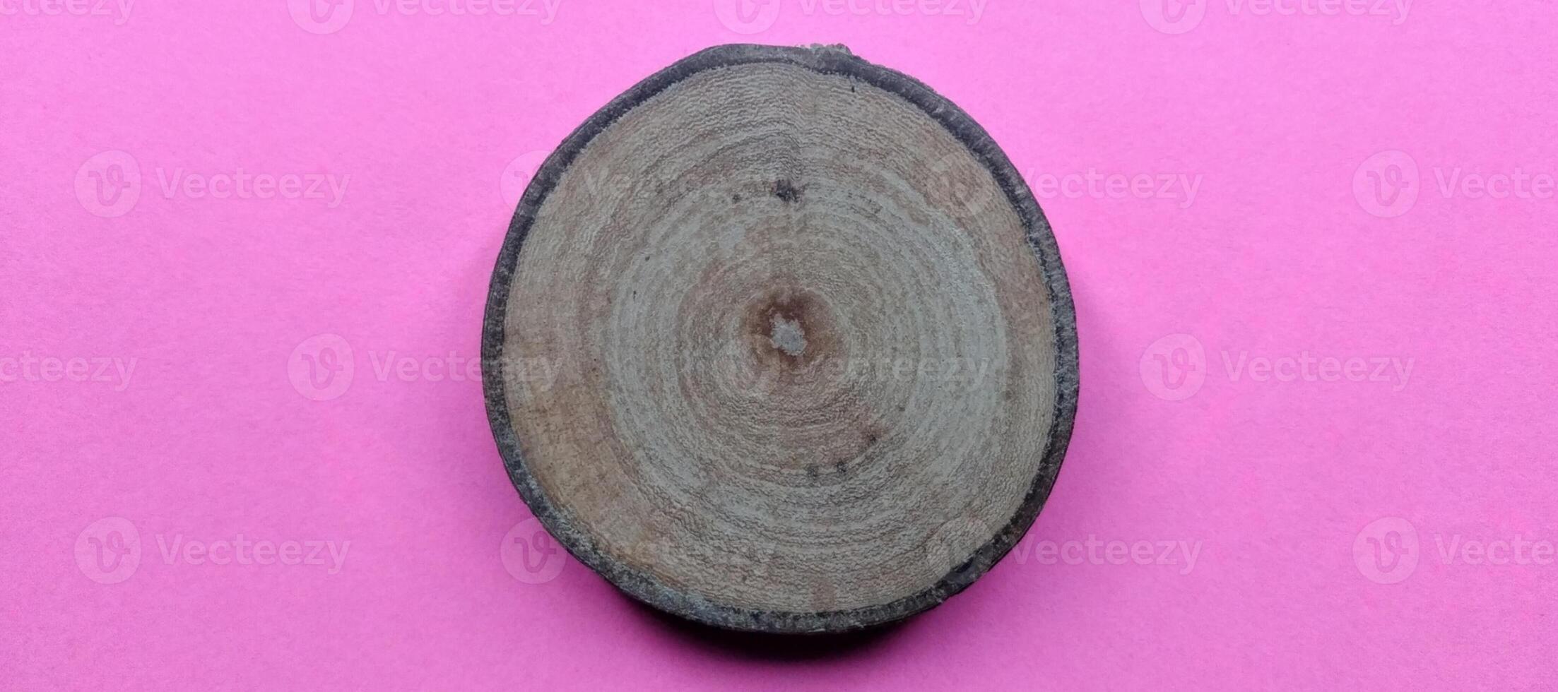 Wooden circle on pink background. Top view with copy space. photo