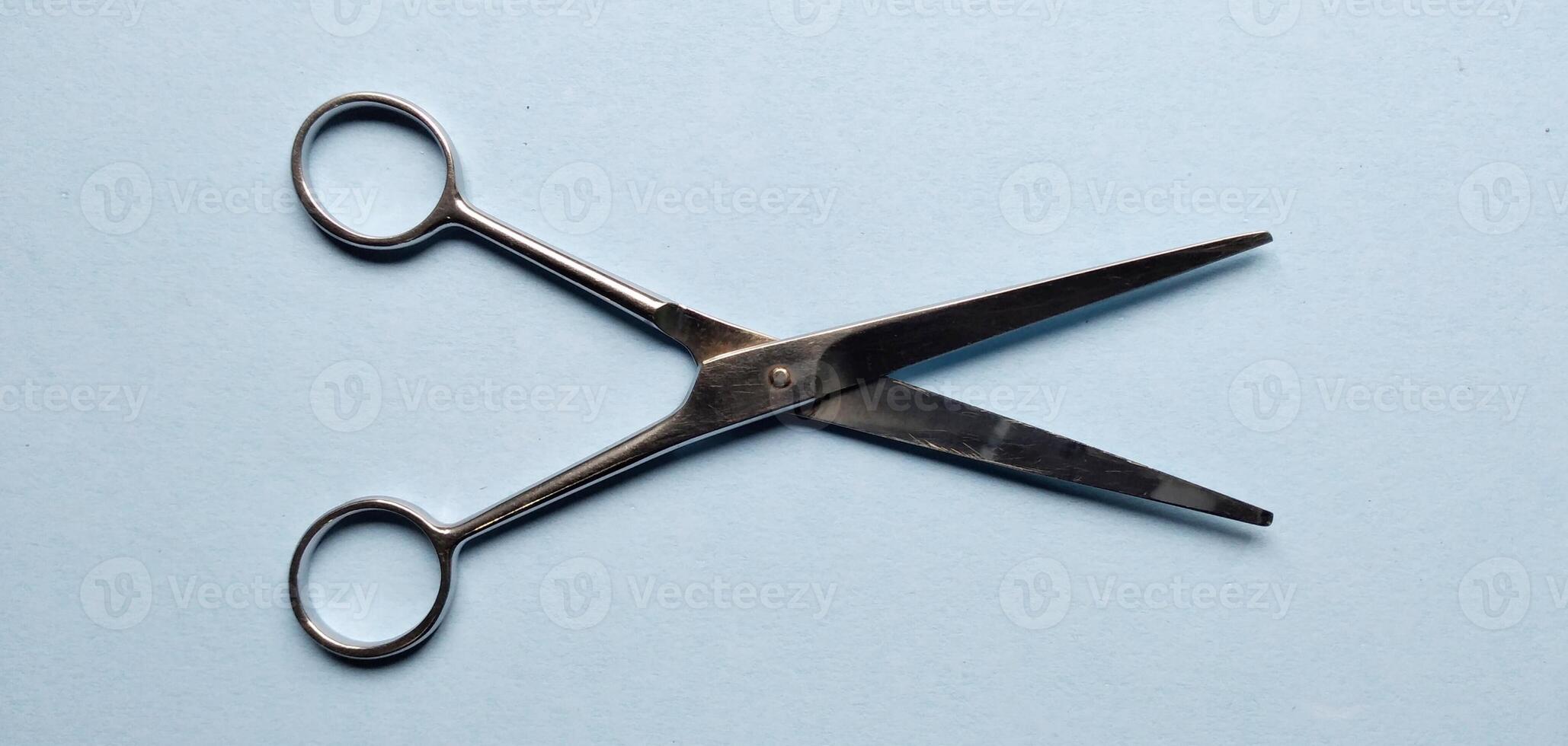 Hair cutting scissors on blue background. Hairdresser tools. photo