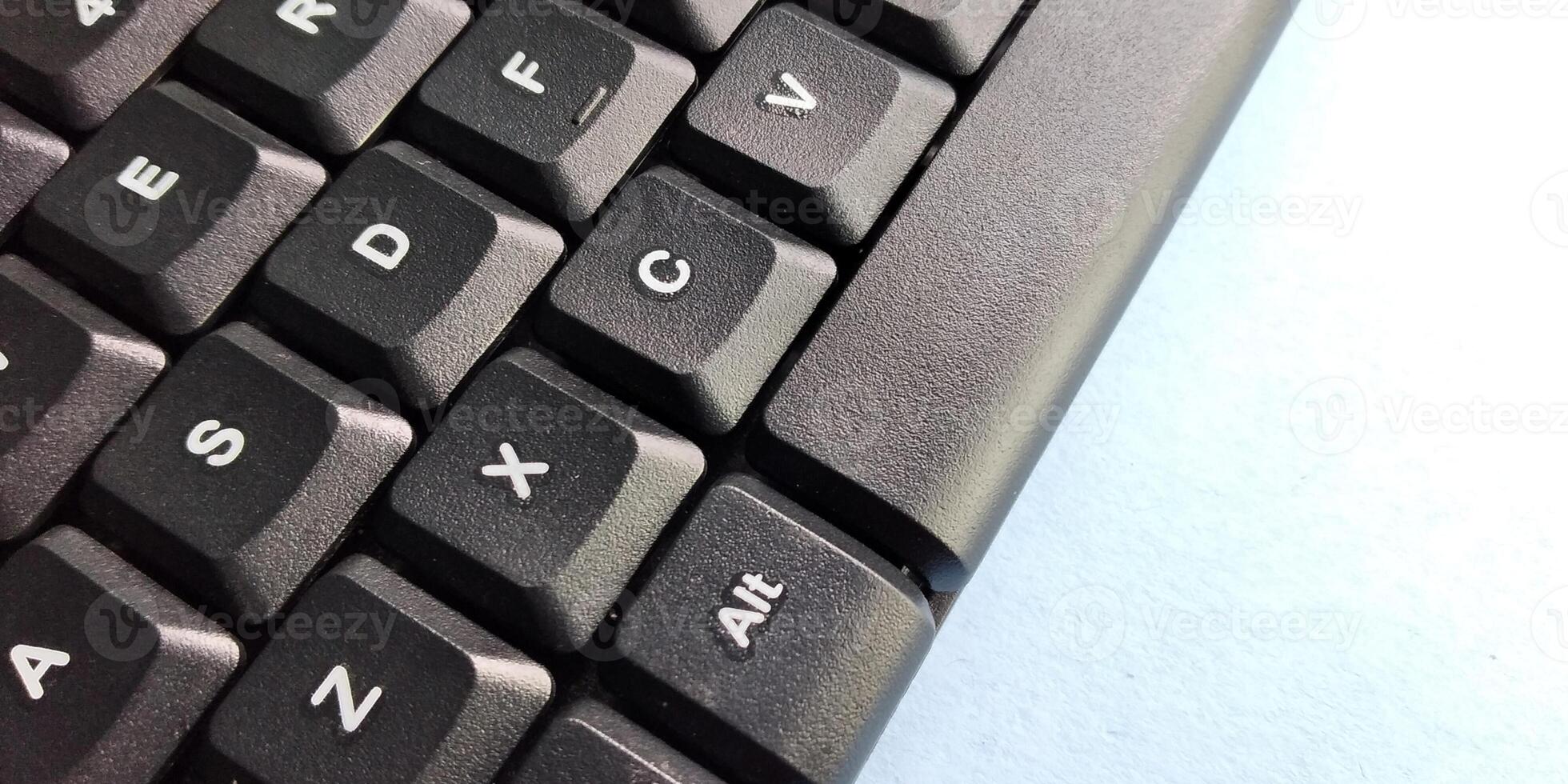 Close up of a black computer keyboard on a blue background with copy space photo