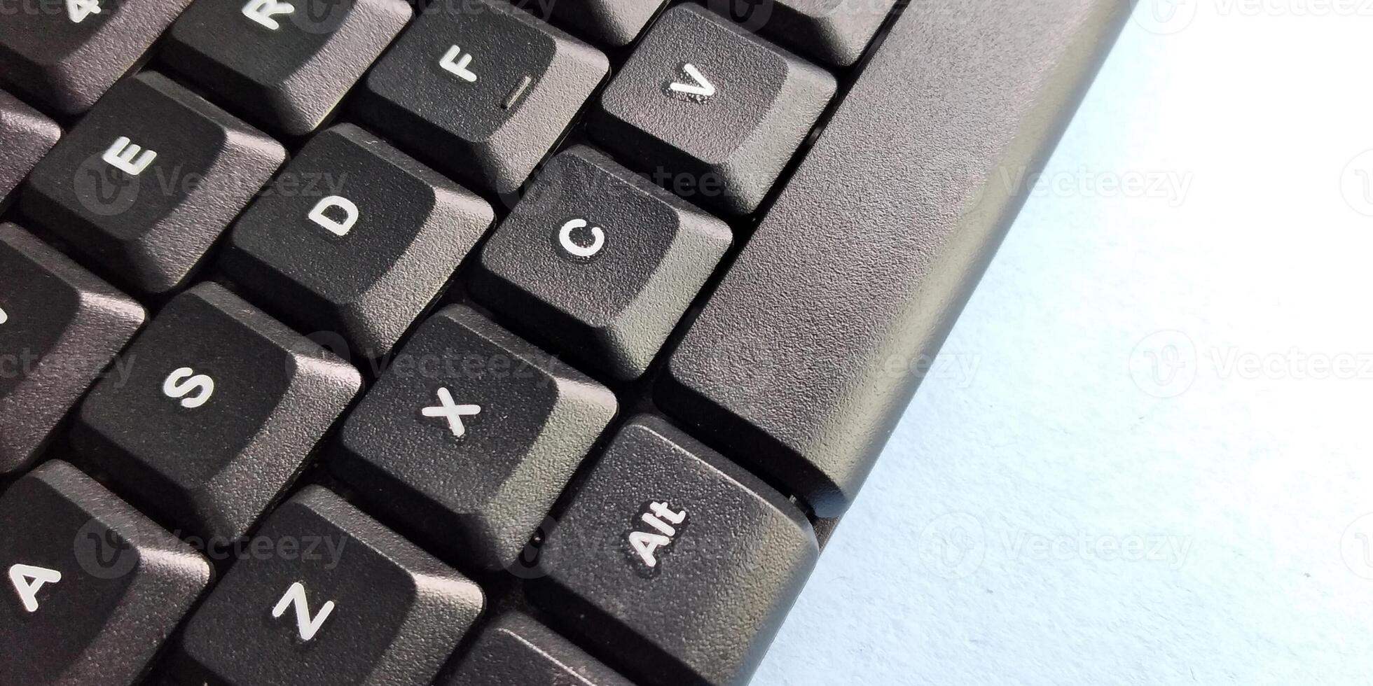 cerca arriba de un negro computadora teclado en un azul antecedentes con Copiar espacio foto