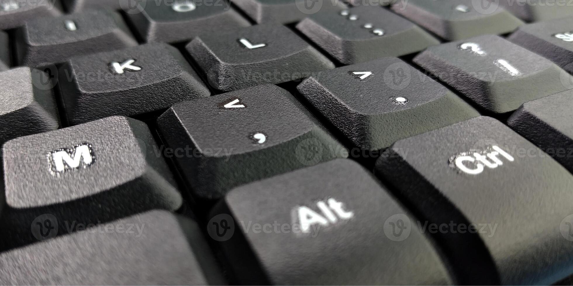 Close up of a black computer keyboard on a blue background with copy space photo