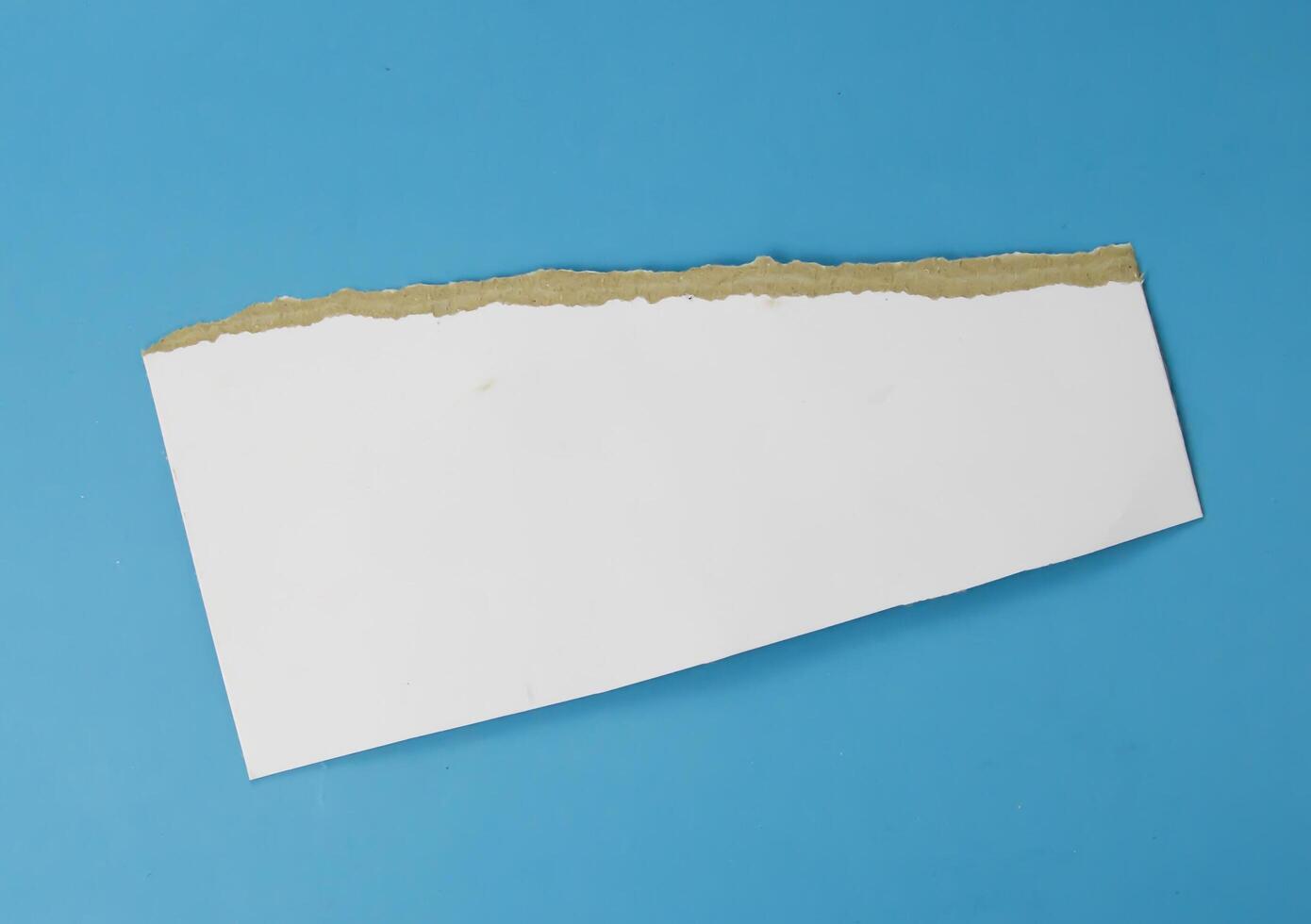 A white paper teared on isolated blue background used for element of design photo