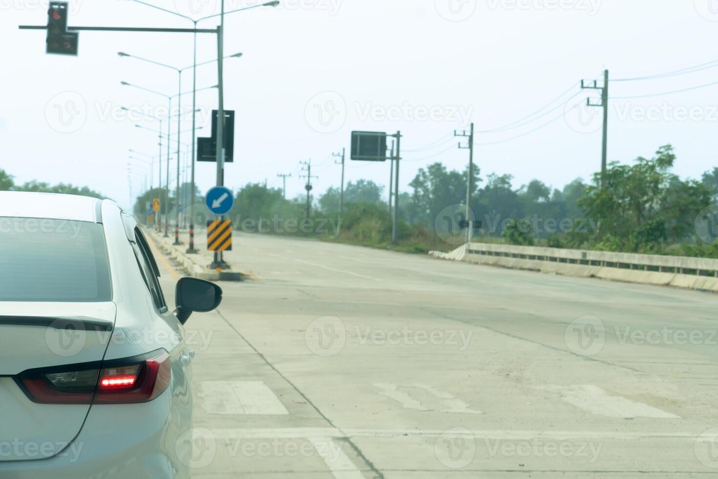 Rear side view of back side car can see signal of turn light. Cars turning right on intersections with traffic lights. Empty concrete road with no car traffic. photo