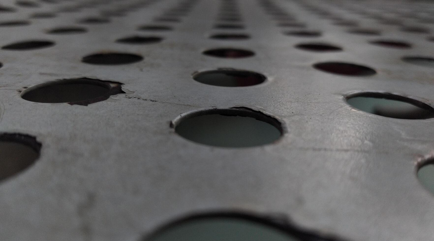 Close-up of a metal grid with holes in the center. photo