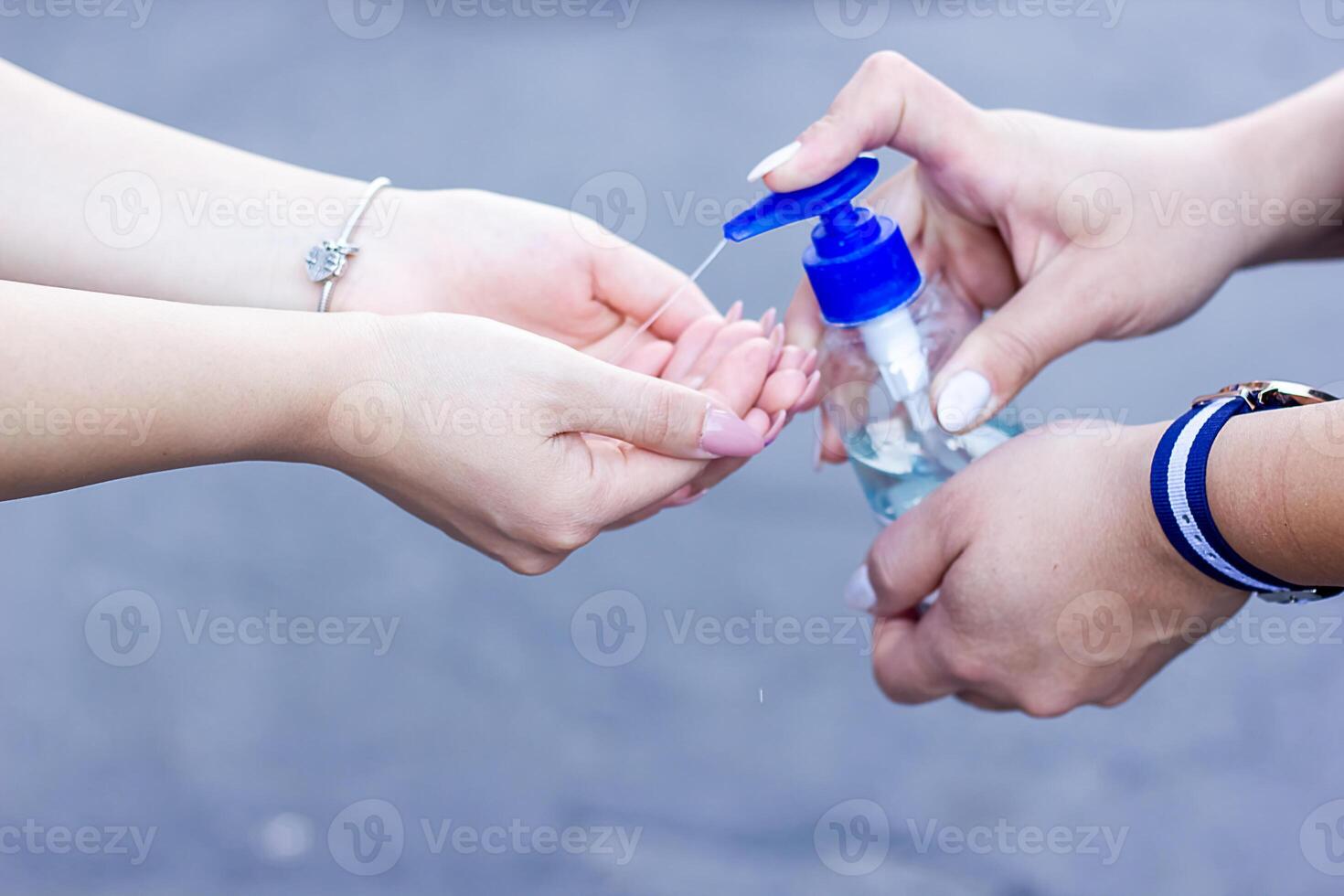 dos muchachas Lavado su manos con alcogel foto