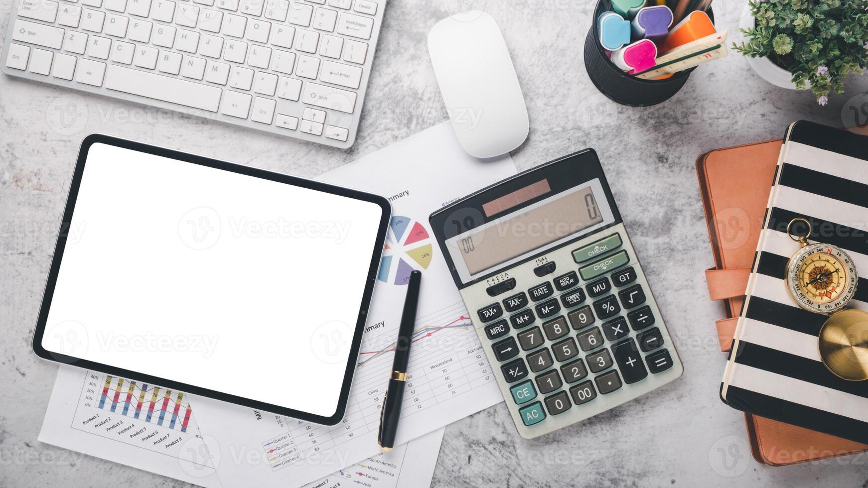 Financial charts on clipboard with a digital tablet, calculator, and a cup of coffee on a rustic blue wooden table. photo