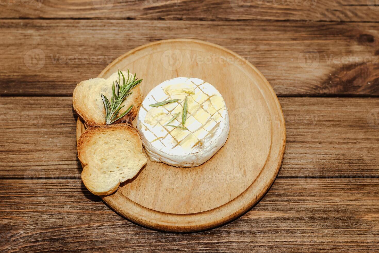 White baguette cut into pieces with olive oil and Camembert cheese on the table. photo