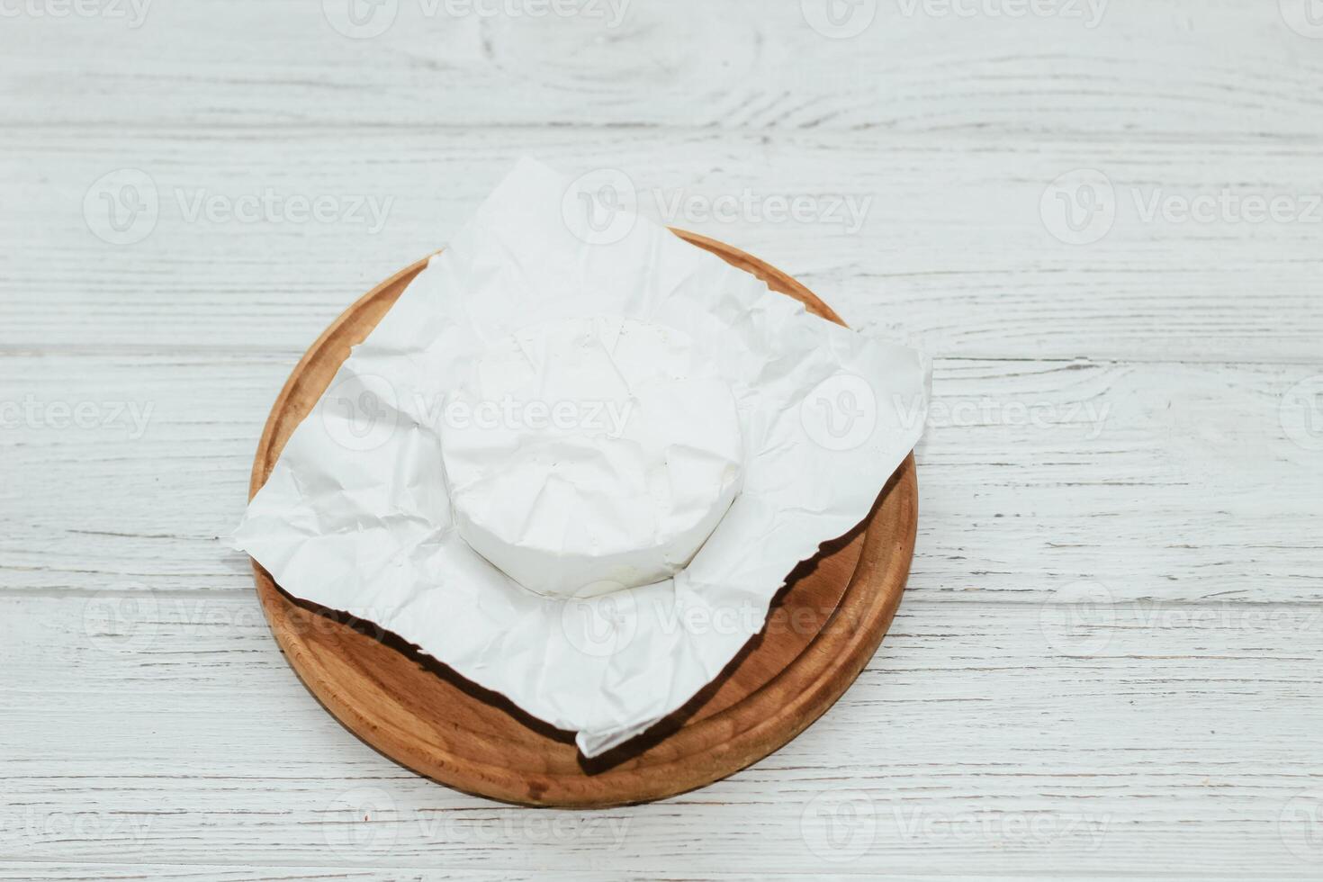 Camembert cheese unwrapped from packaging on the table. photo