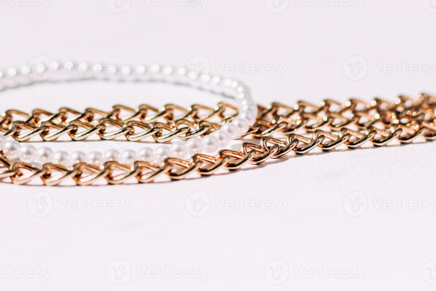 A necklace of white beads with chains of jewelry on a white aesthetic background. photo