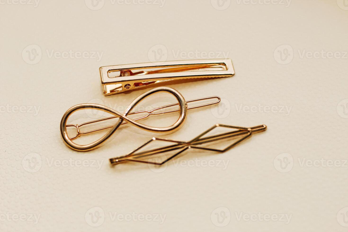 Gold ornaments from yellow metal on a light background. photo