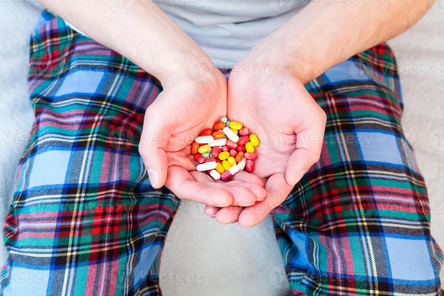 Man holds many multicolored pills in hands. Taking vitamins, supplements, antibiotic, antidepressant and painkiller medication. Close-up. photo