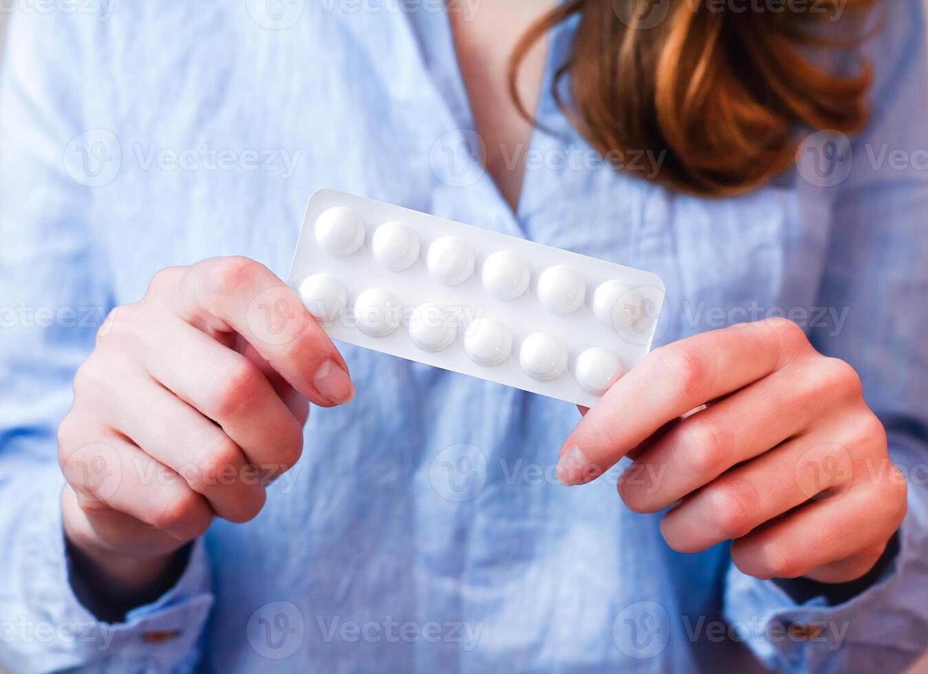 joven mujer sostiene pastillas en manos. tomando vitaminas, suplementos, antibiótico, antidepresivo, analgésico medicamento. prenatal vitaminas de cerca. selectivo enfocar. foto