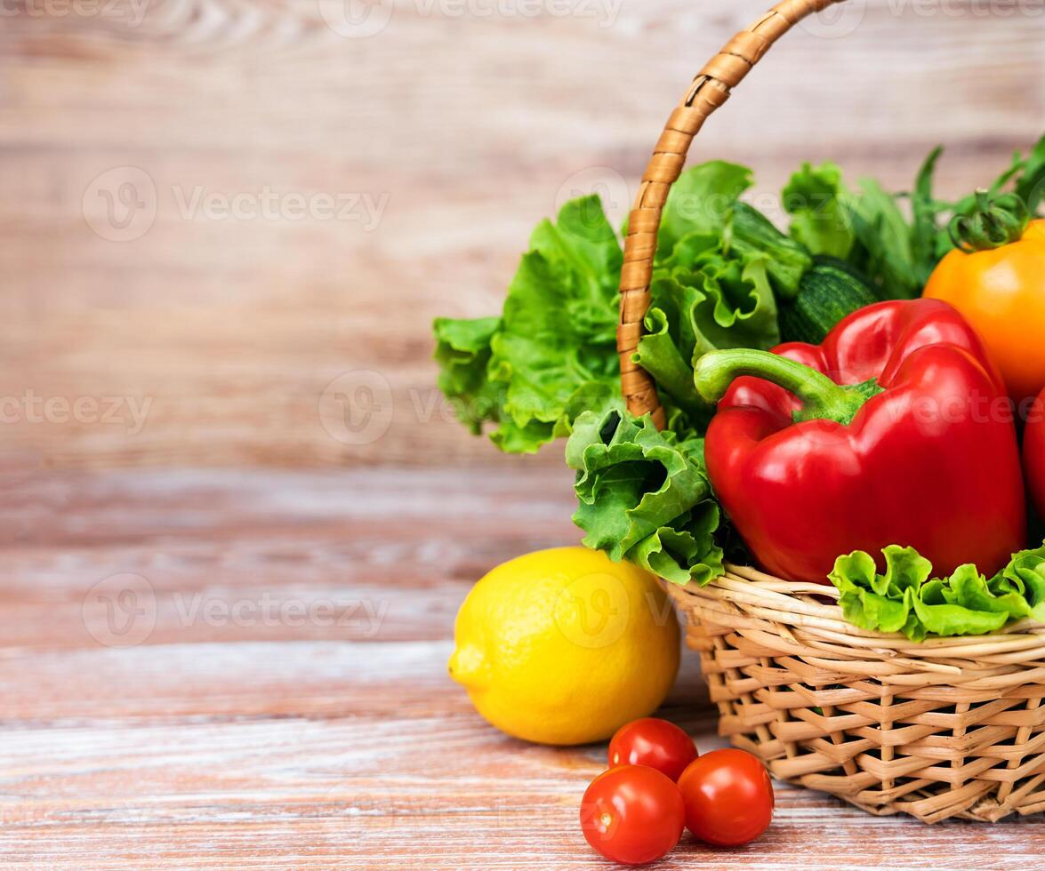 Basket with vegetables and greenery on a wooden table. Healthy eating, harvest, Thanksgiving Day. Close-up. Copy space. photo
