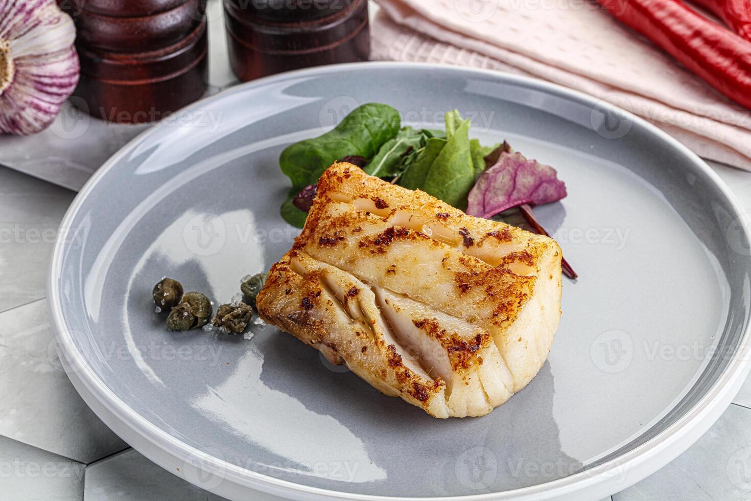 Roasted cod fish steak with salad photo