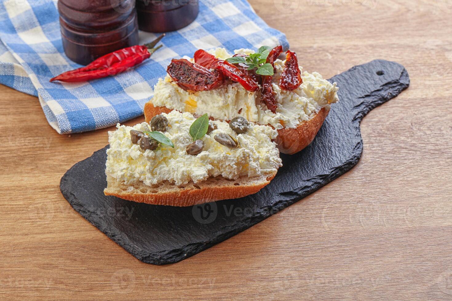 bruschetta with soft cheese capers and tomato photo