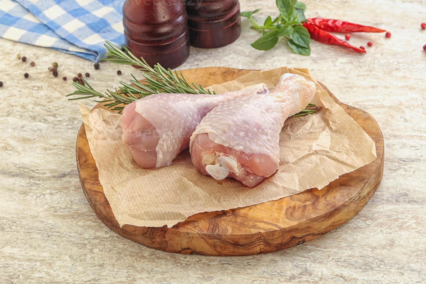 Raw chicken leg over board photo