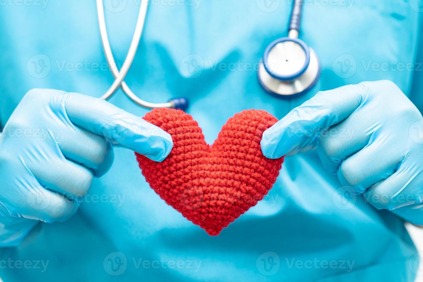 Doctor holding a red heart in hospital ward, healthy strong medical concept. photo