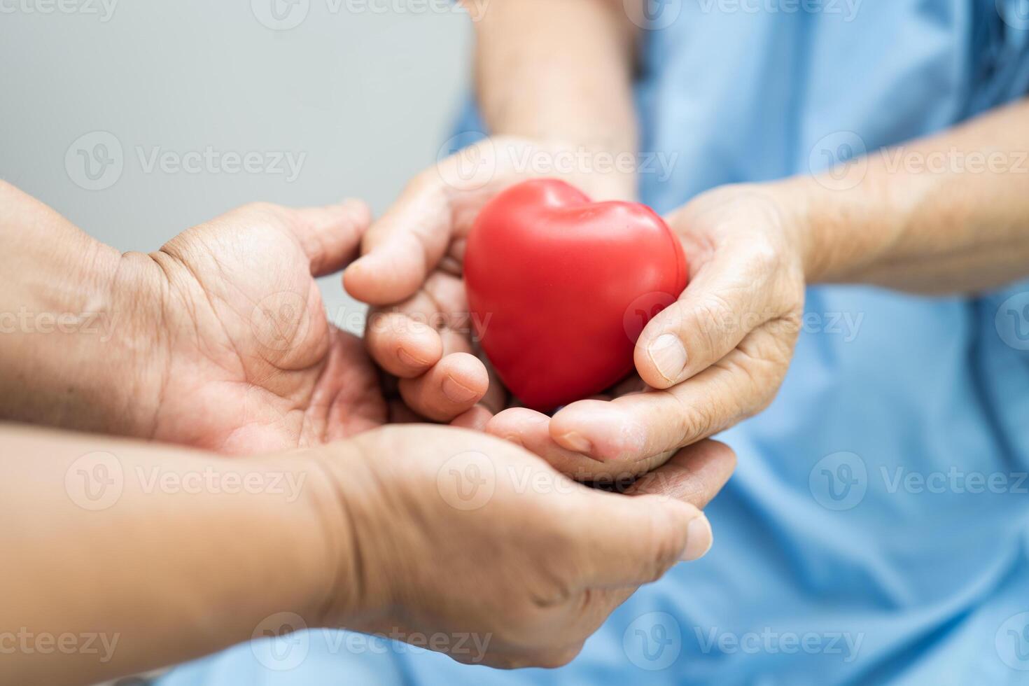 Doctor holding a red heart in hospital, healthy strong medical concept. photo