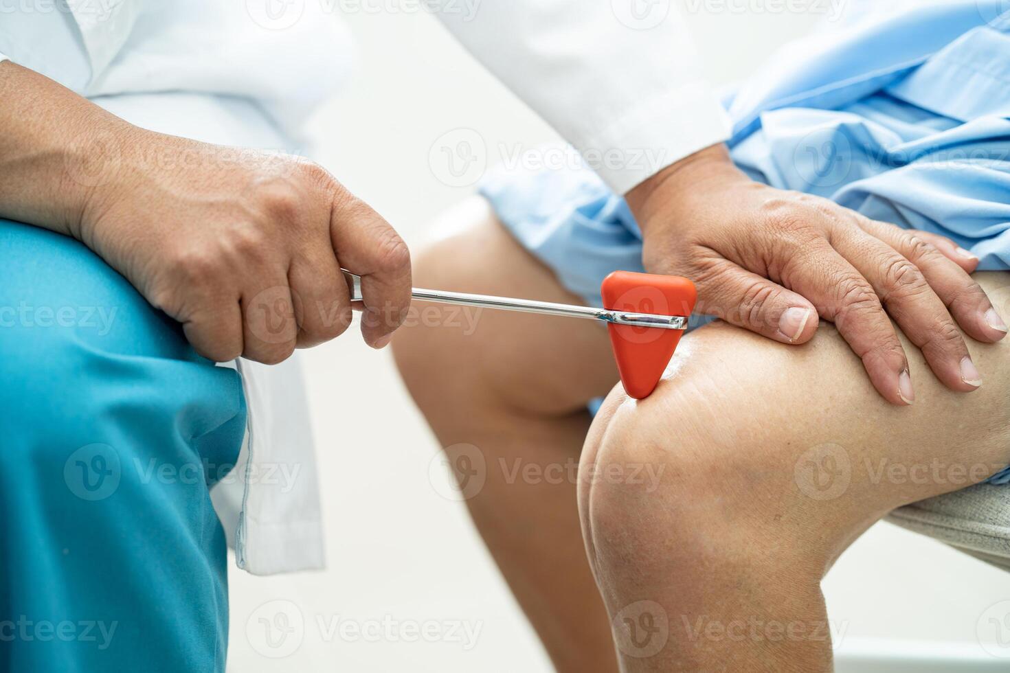 asiático médico utilizar martillo golpe mayor mujer paciente a cheque rodilla reflejo, nervio y músculo en hospital. foto