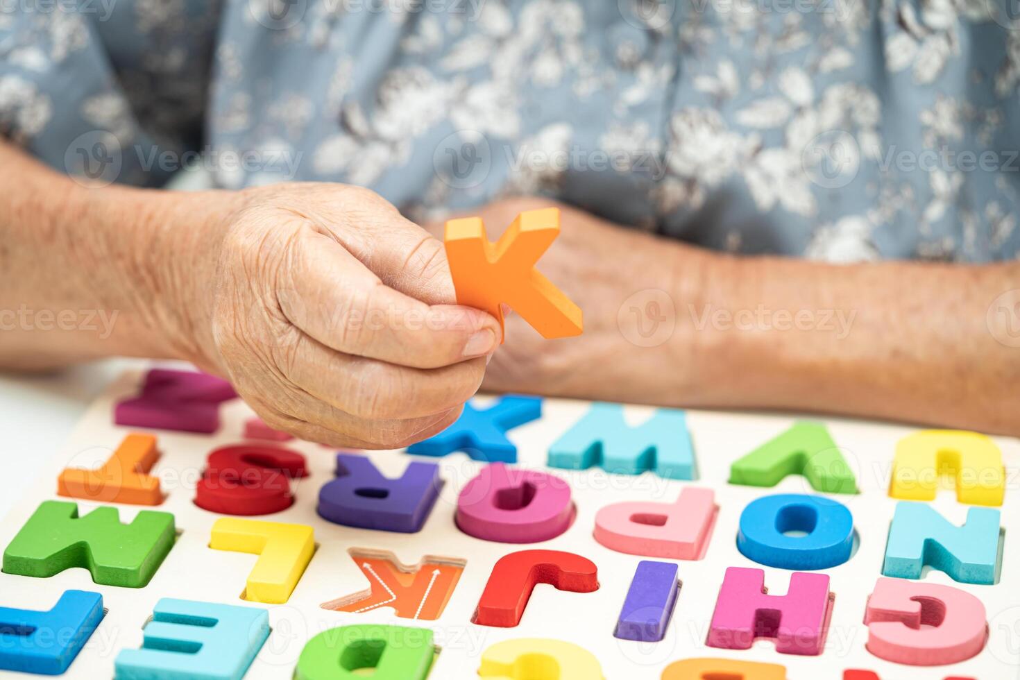 Alzheimer disease AD, Asian elderly woman patient suffering from dementia learn practical motor skills rehabilitation. photo