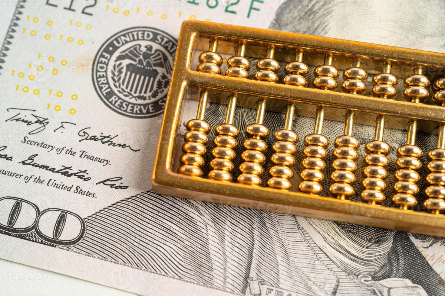 Gold abacus on US dollar banknote money, economy finance exchange trade investment. photo