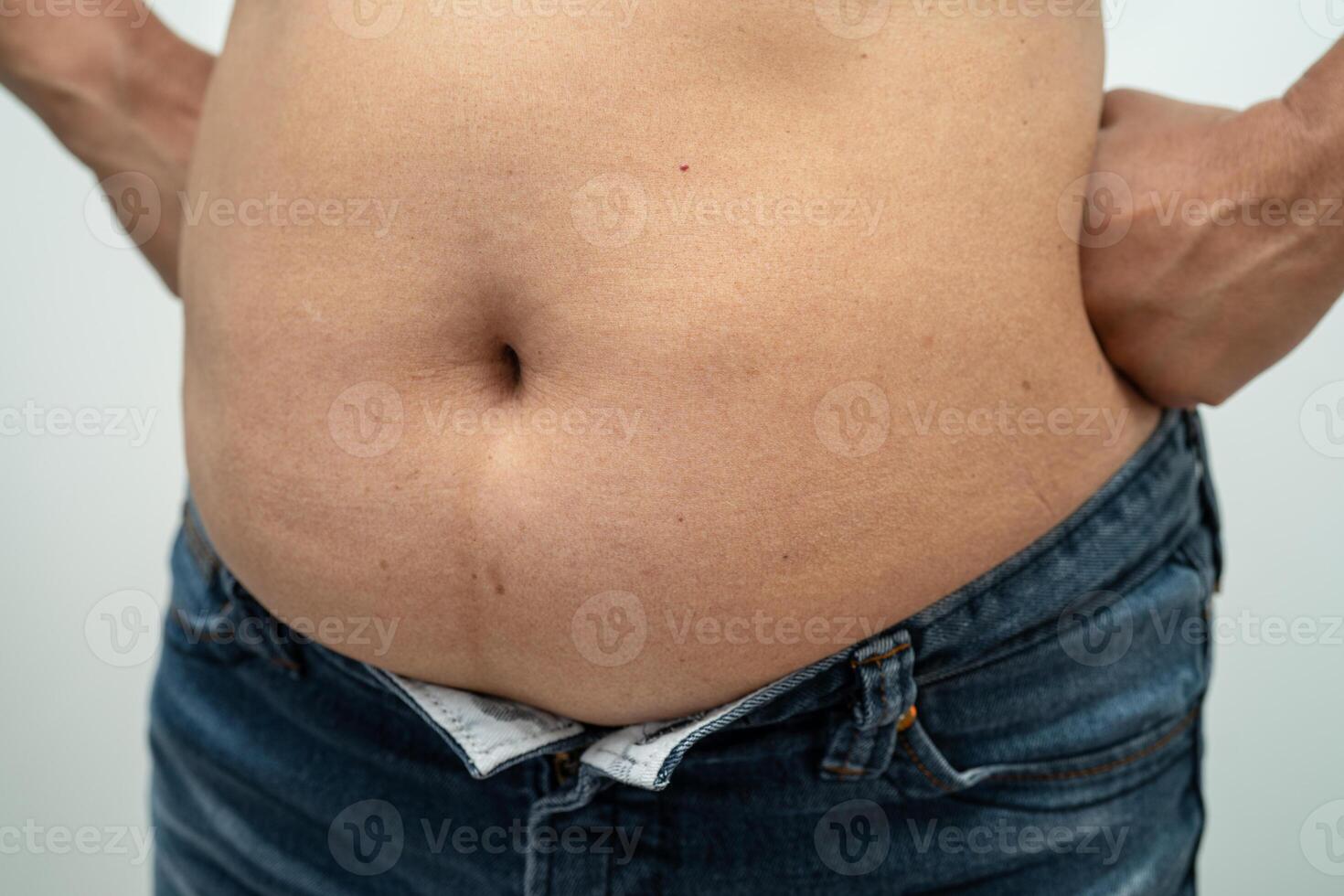 mujer asiática con sobrepeso muestra y usa la mano para apretar el vientre gordo. foto