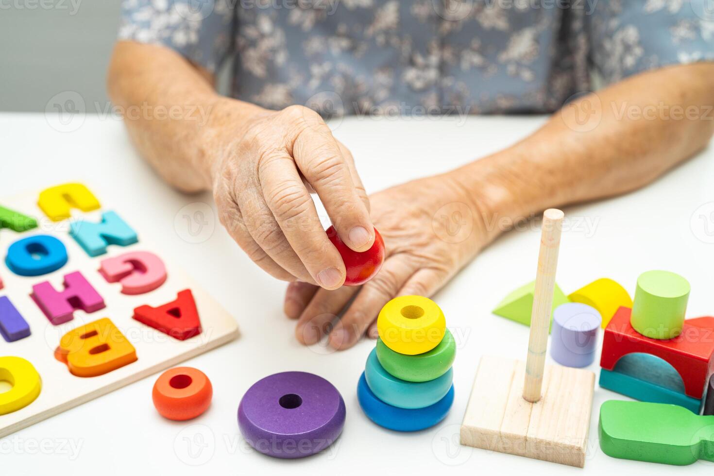 Alzheimer disease AD, Asian elderly woman patient suffering from dementia learn practical motor skills rehabilitation. photo