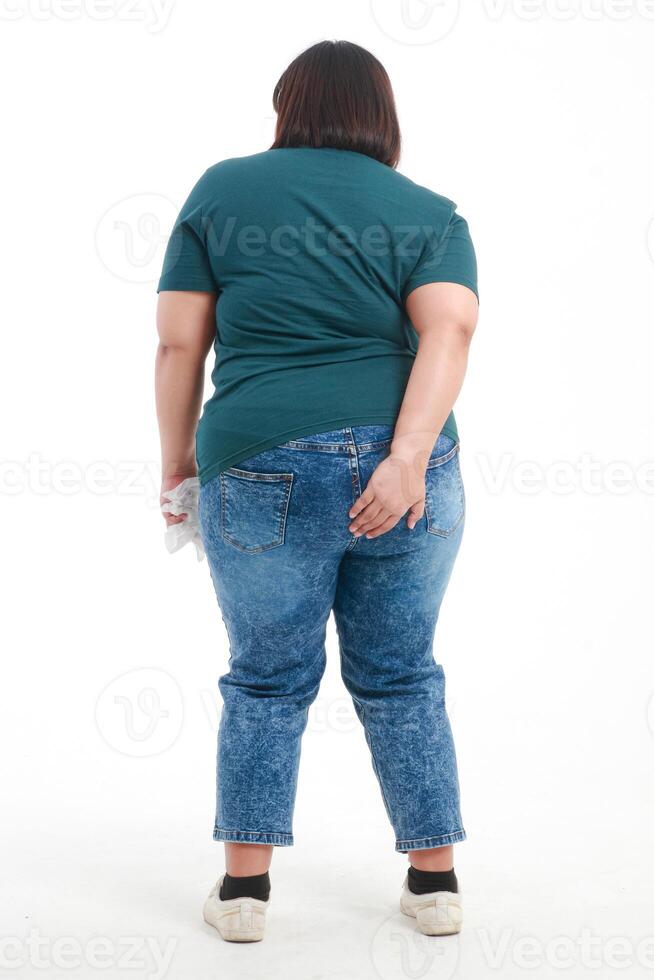 Fat Asian woman standing with her back standing on a white background She had a stomachache and wanted to go to the toilet. Health care, check for symptoms of easy diarrhea or intestinal inflammation photo