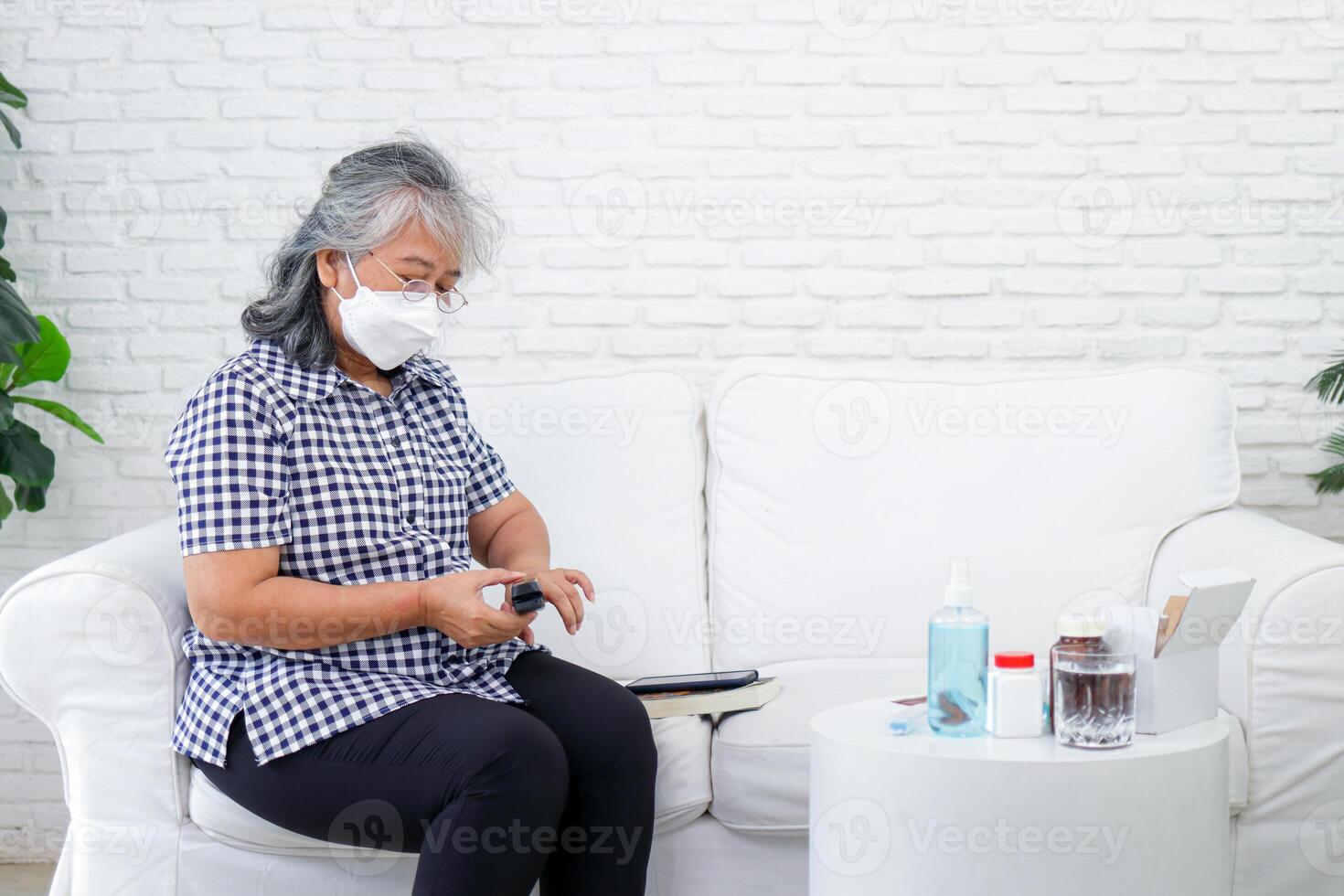 Asian elderly woman Measure fingertip oxygen by yourself help keep an eye out and monitor symptoms of COVID-19. The concept of patients staying at home. photo