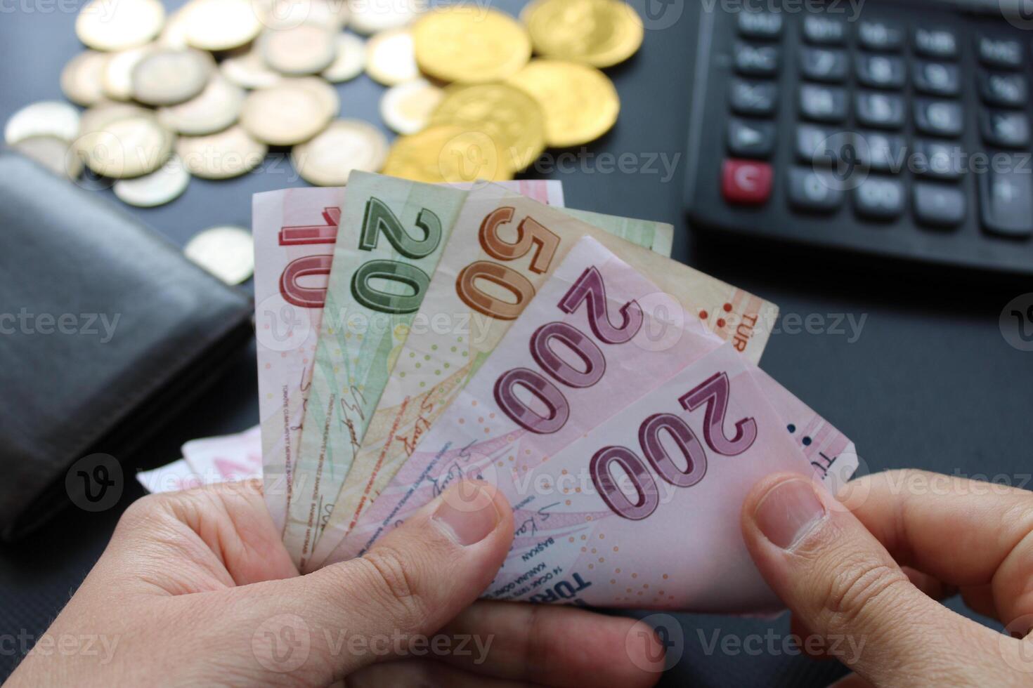 hombre contando turco dinero con su mano. turco lira Billetes el papel moneda de calculadora.turquia en el antecedentes. para impuesto y caminata noticias. foto