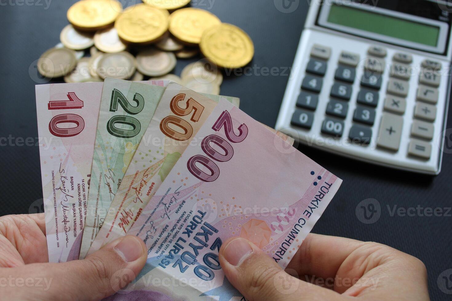 man counting Turkish money with his hand. Turkish lira banknotes. The paper currency of Turkey.Calculator in the background. For tax and hike news. photo