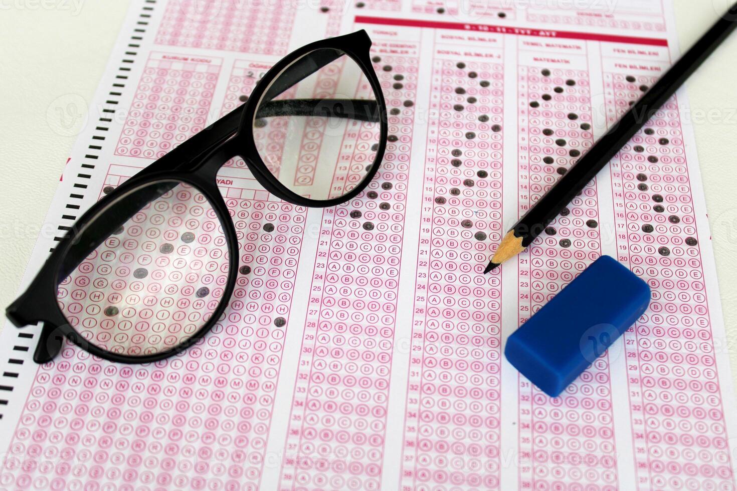 Optical reader, pencil, glasses, and eraser on it. Exam, idea conspet. Future Anxiety. Uncertainty. Multiple choice exam.Adults taking the exam. photo