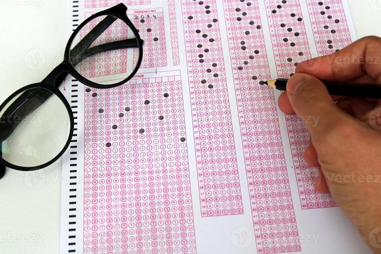 Optical reader, pencil, glasses, and eraser on it. Exam, idea conspet. Future Anxiety. Uncertainty. Multiple choice exam.Adults taking the exam. photo