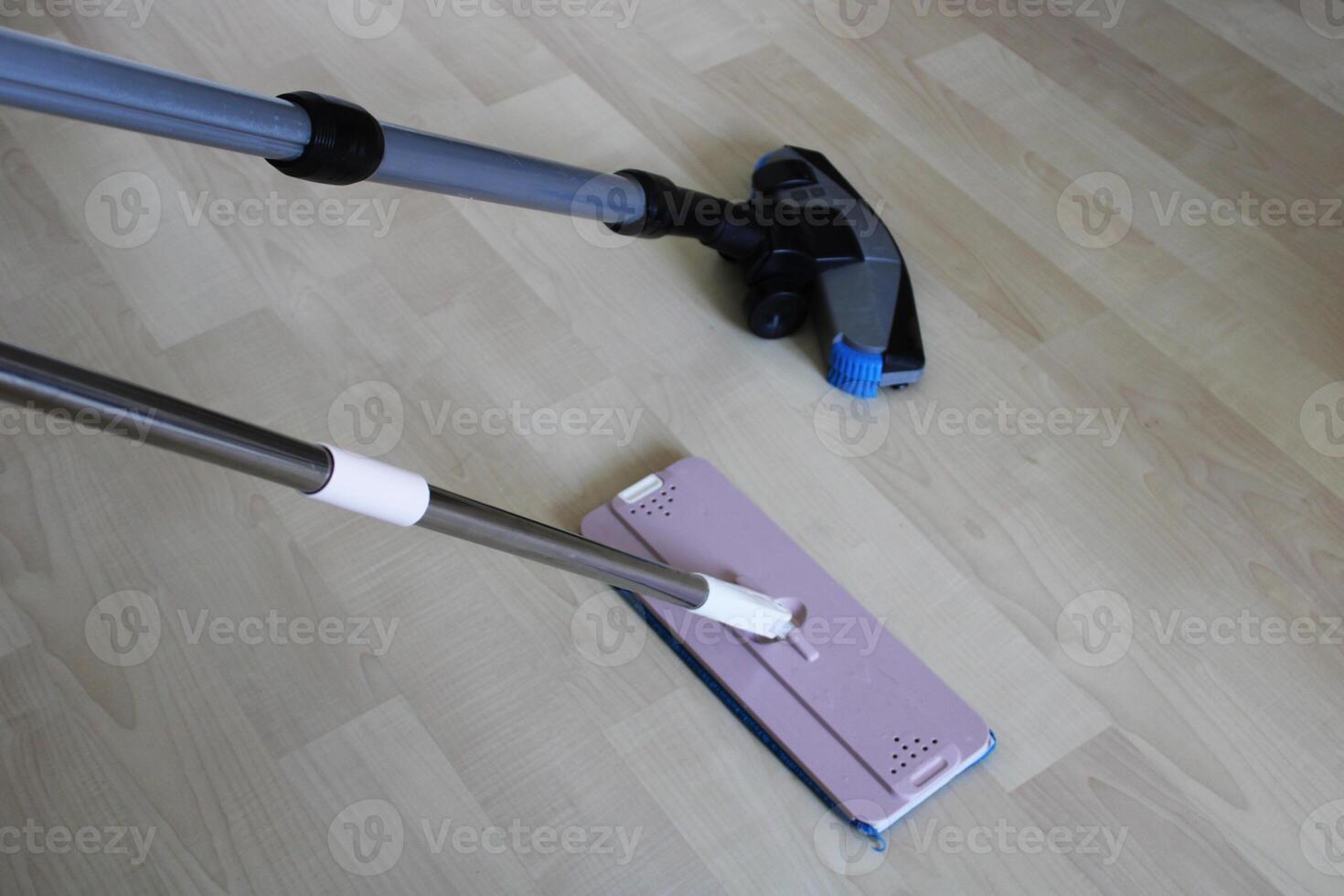 Cleaning material and vacuum cleaner on wooden floor. home cleaning photo