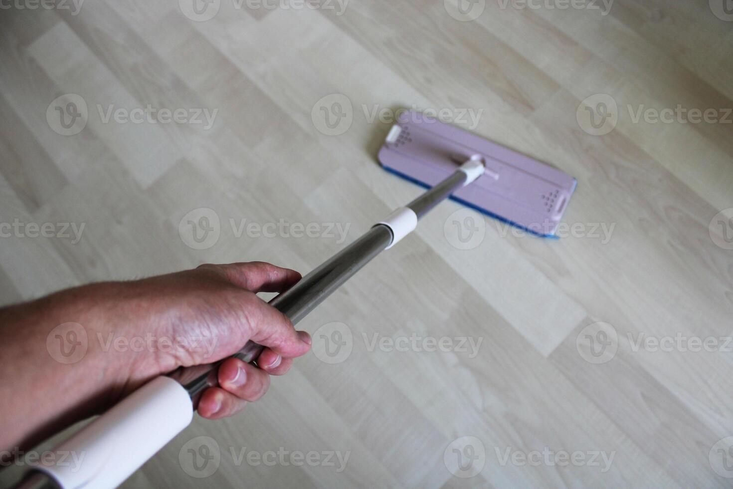 person is cleaning a floor by use of a cleaning machine.mop cleaning on floor at home photo