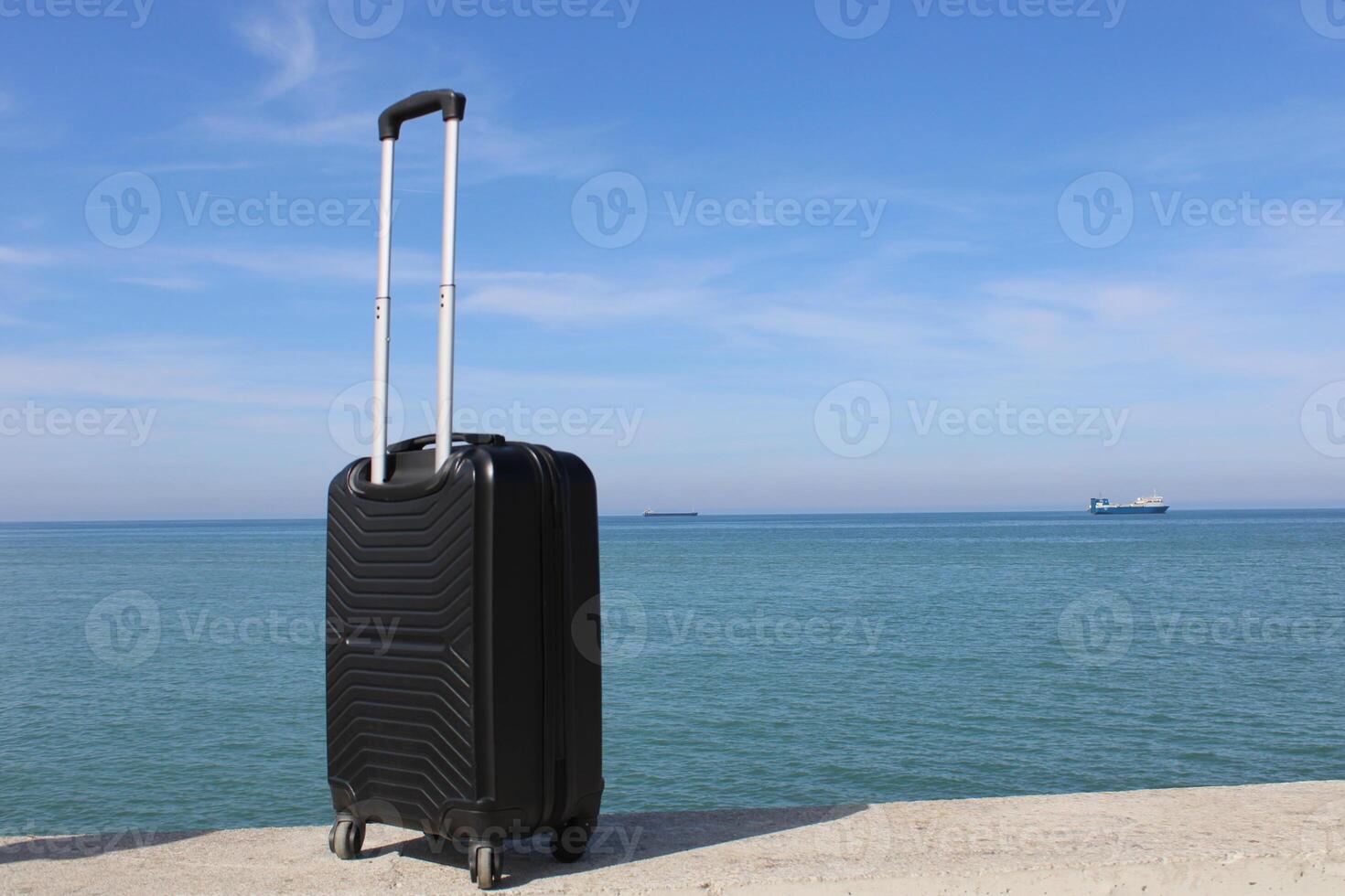 A suitcase is standing on a beach with a sunset in the background. Travel, holiday and vacation consept. Summer time. photo