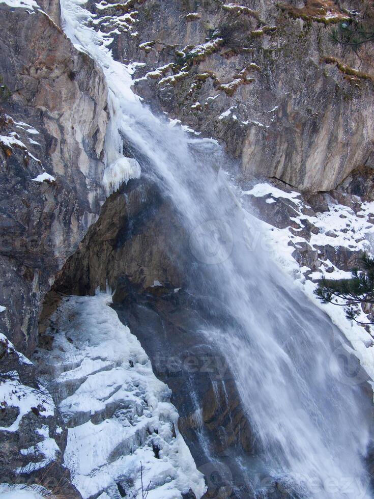 a waterfall in the mountains photo