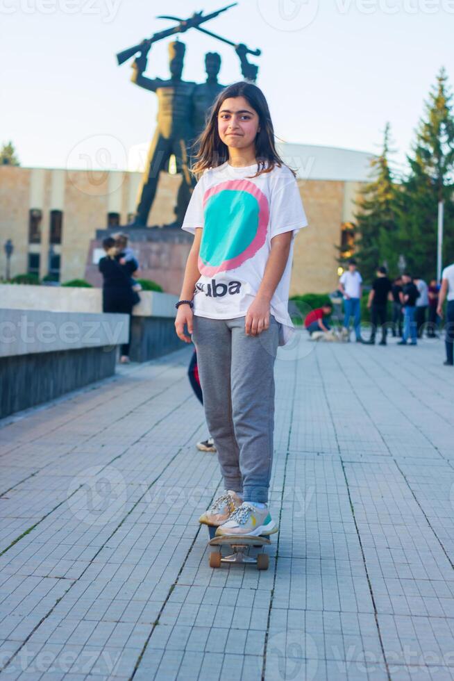 young girl playing on the playground, girl with skateboard, young girl on skateboard in the park photo