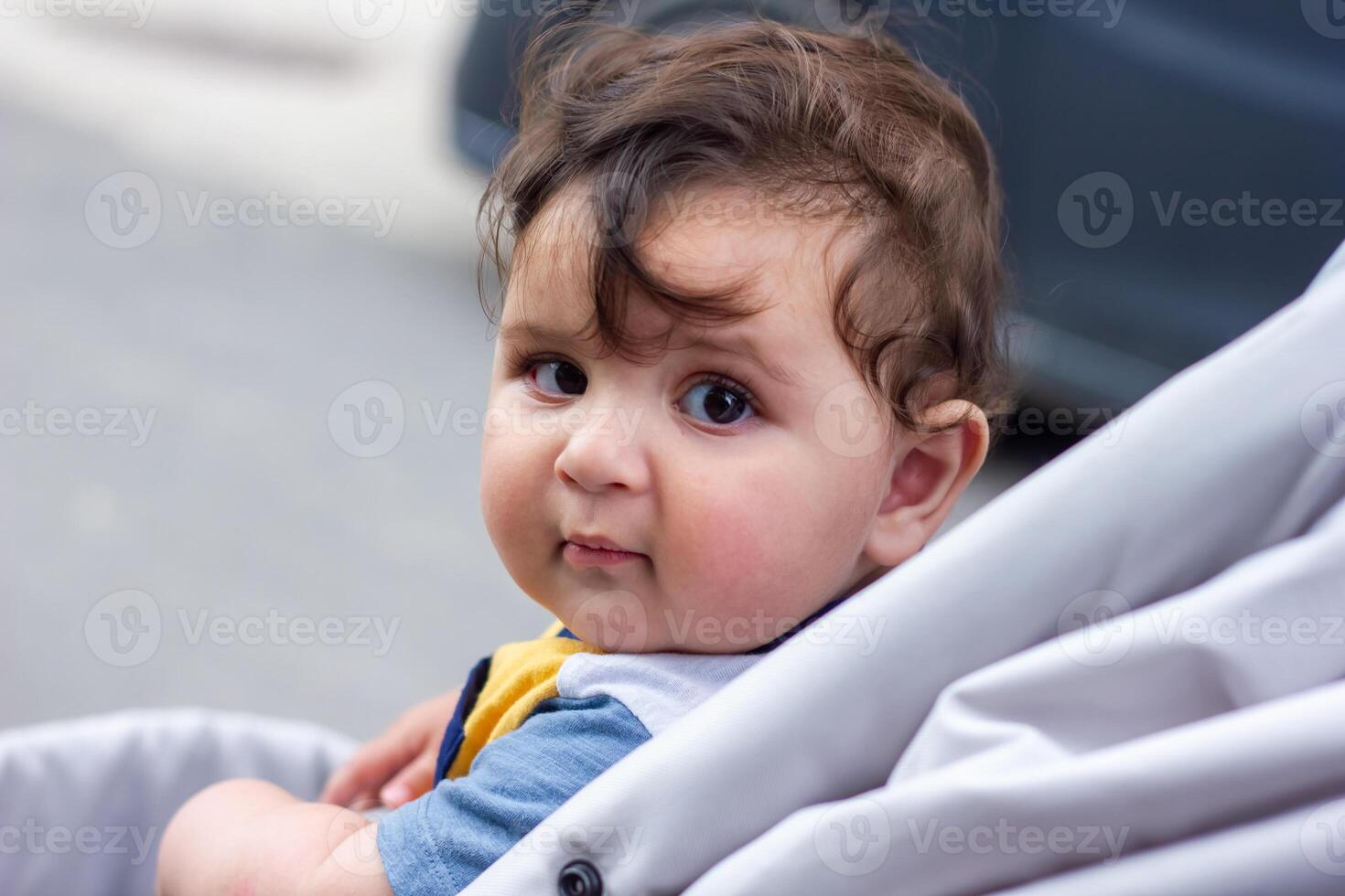 bebé chico en paseante en el jardín foto