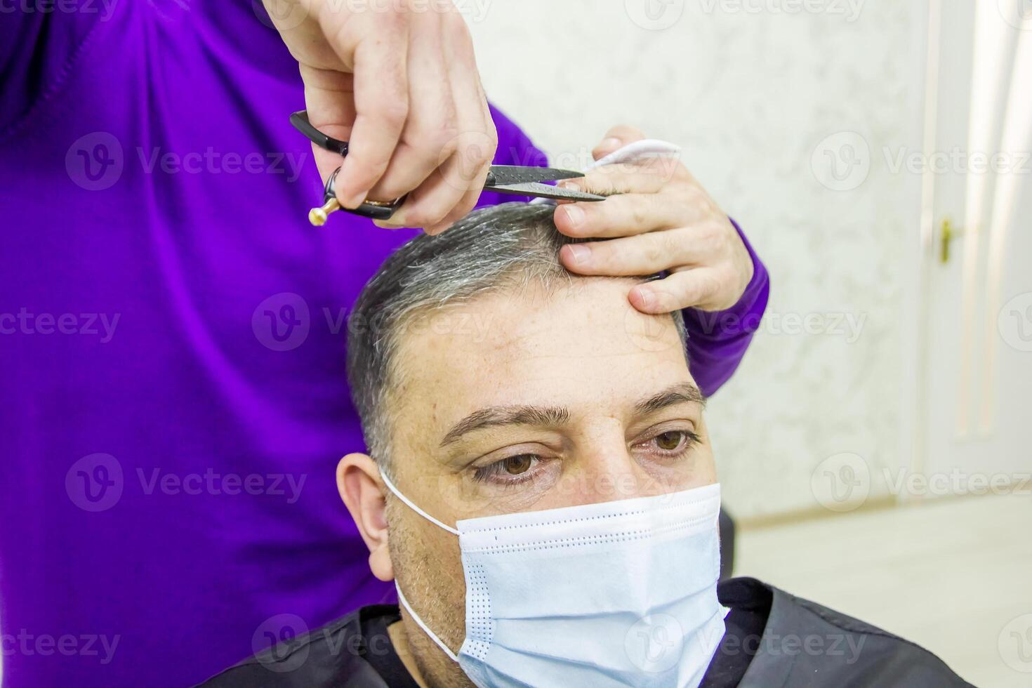 hairdresser is cutting clients hair in barber shop photo