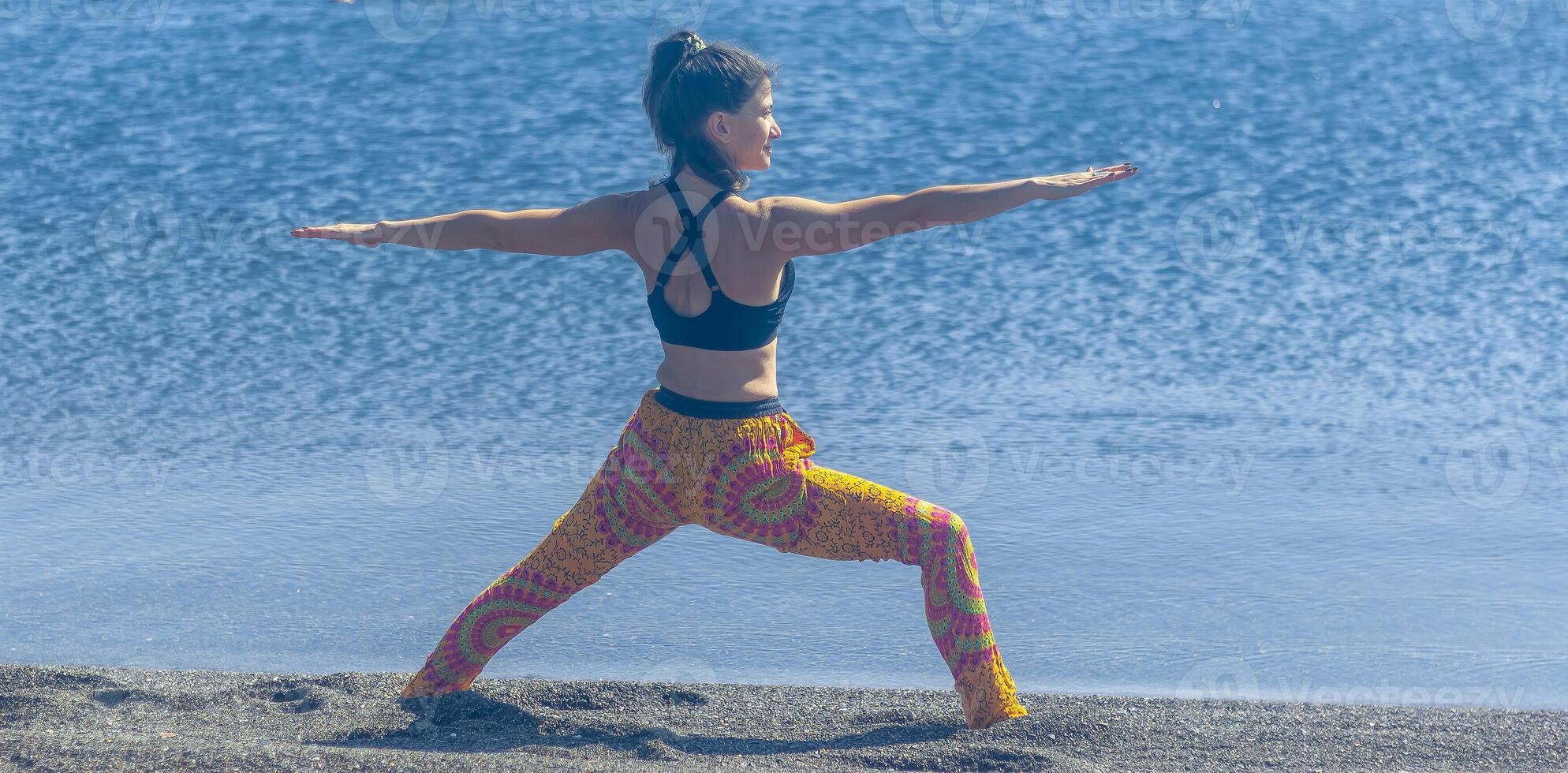 perrson doing yoga exercise on the beach, person relaxing on the beach, personn doing yoga photo