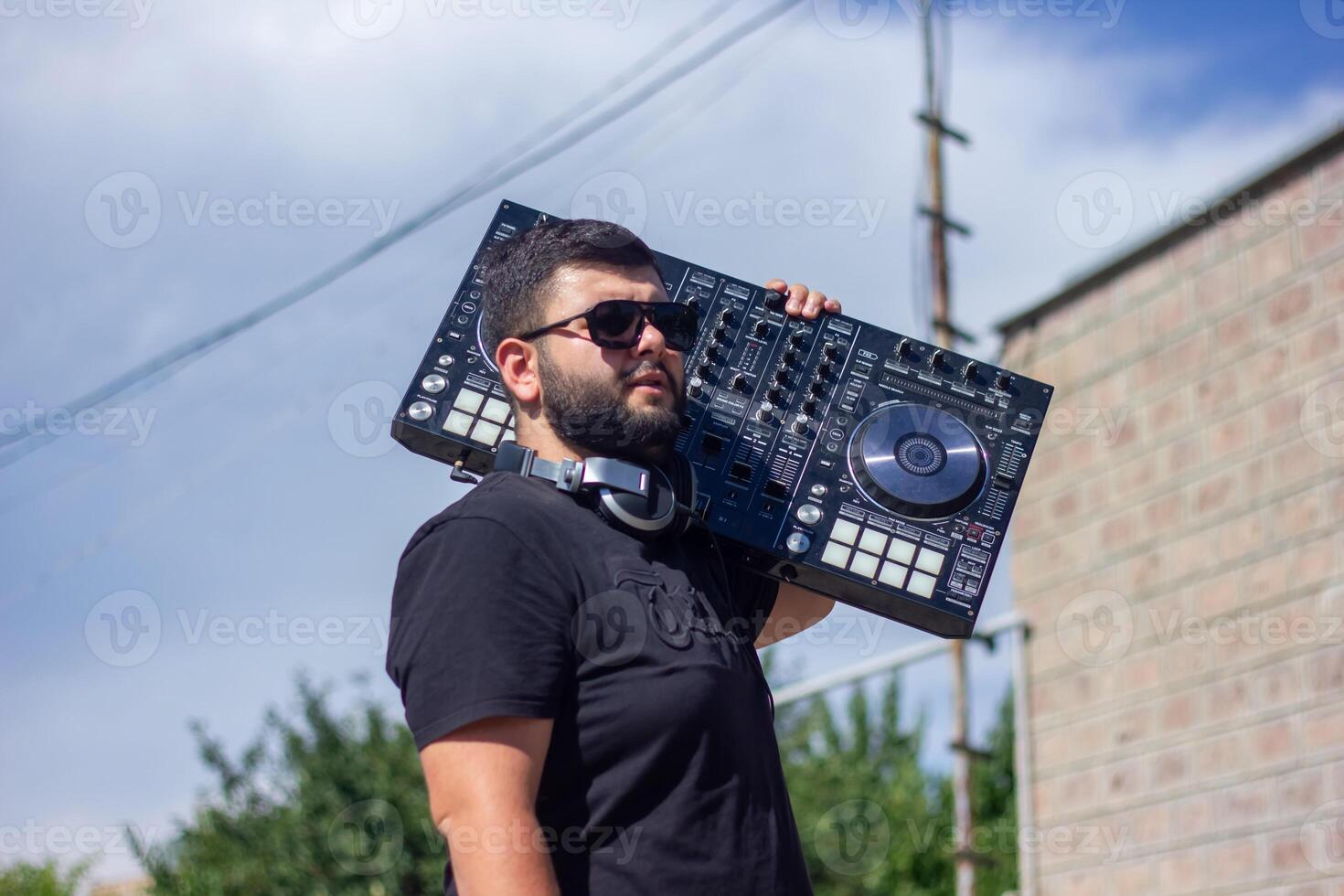 dj with headphones and mixer in the park, the dj at work photo