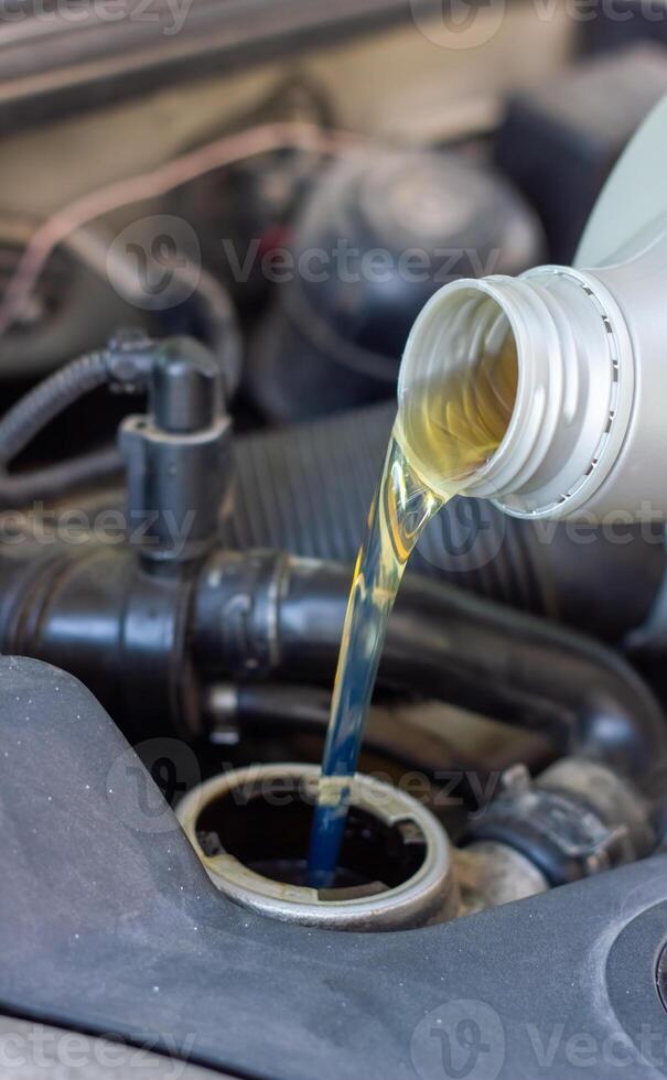 Motor oil pouring to car engine photo