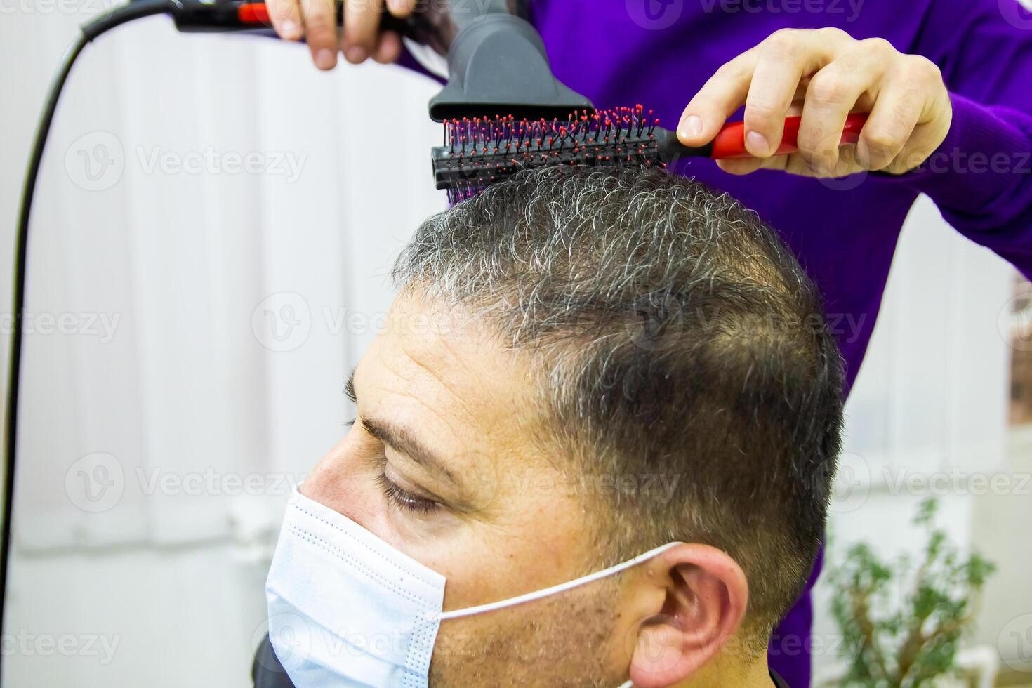 hairdresser is cutting clients hair in barber shop photo