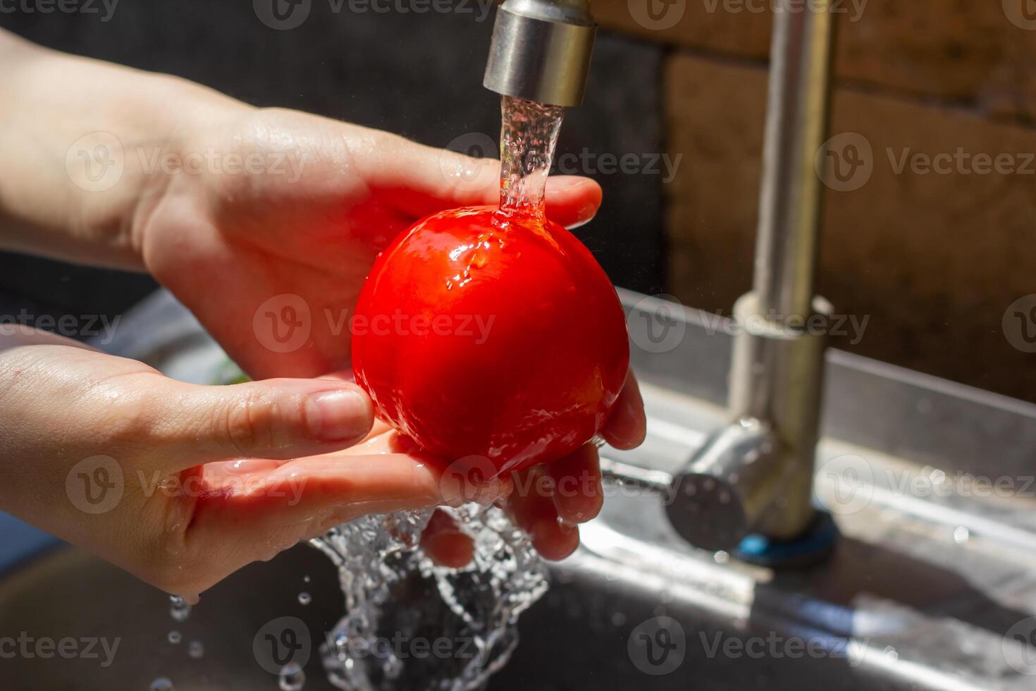 a hands washing berries under the water photo