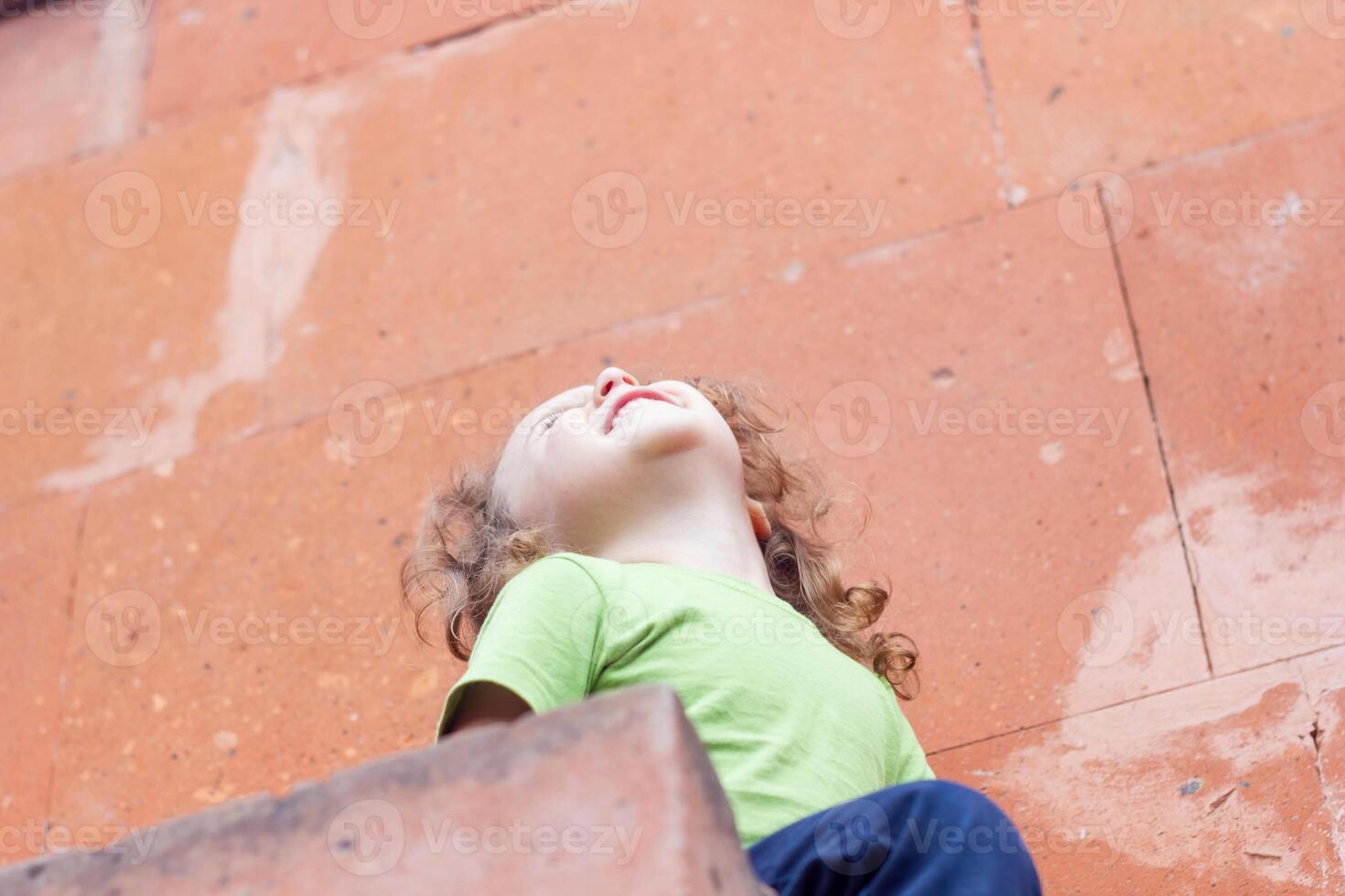 happy little boy playing in the park, long hair boy in the park photo