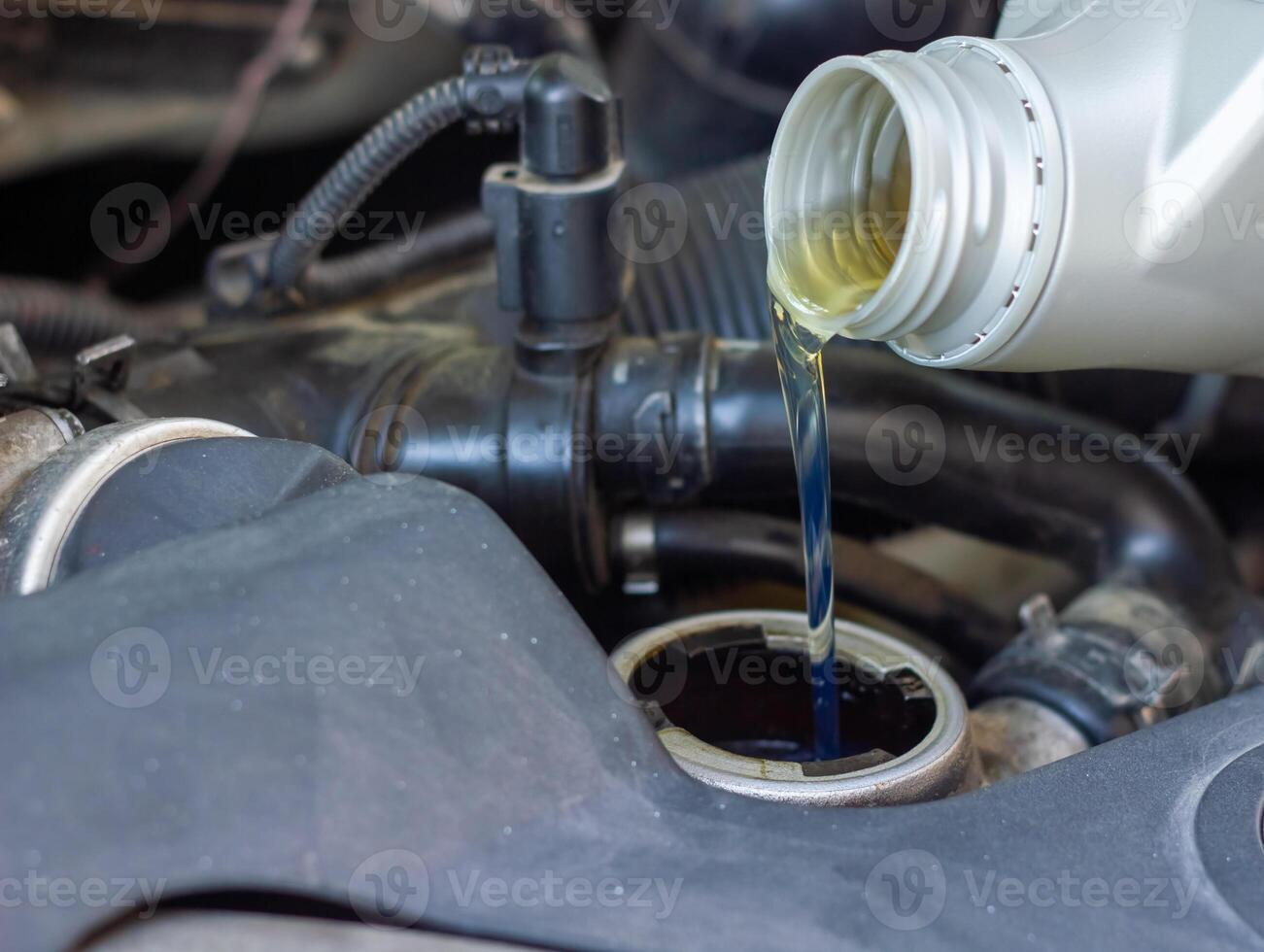 Motor oil pouring to car engine photo