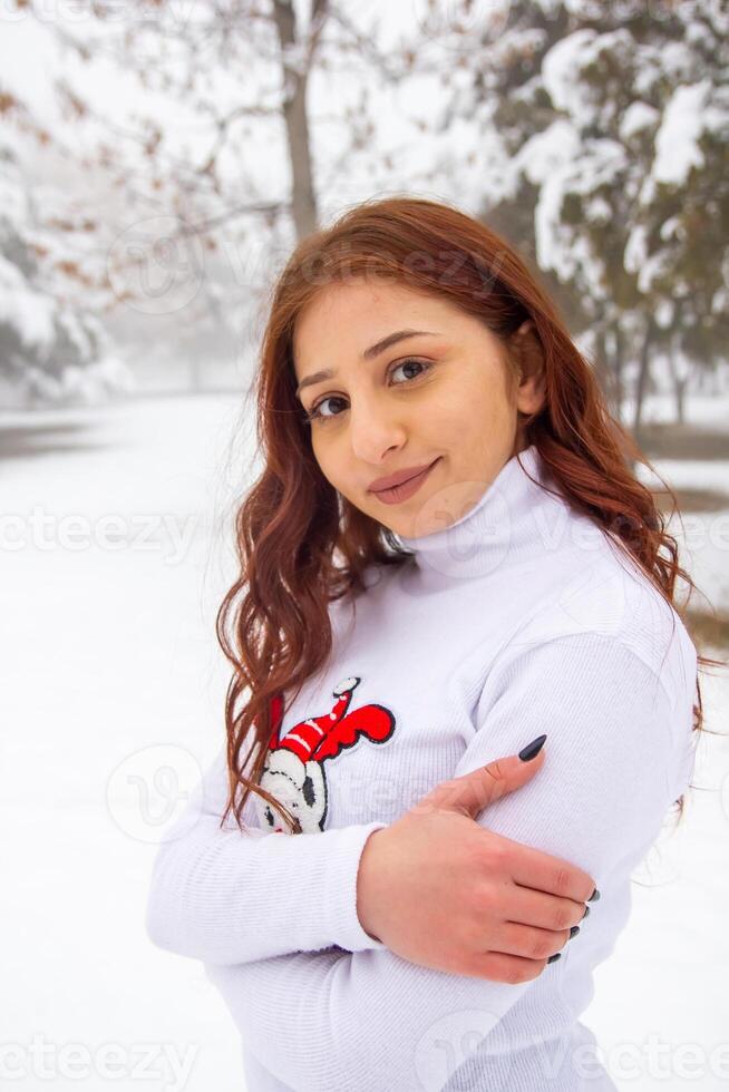 bonito joven mujer en invierno parque, rojo peludo niña en el parque en invierno foto